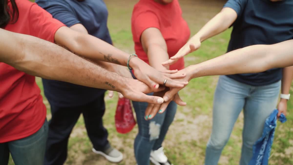 Une équipe réunit ses mains dans un geste collectif