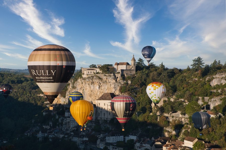 Montgolfières au-dessus d’un village et de falaises