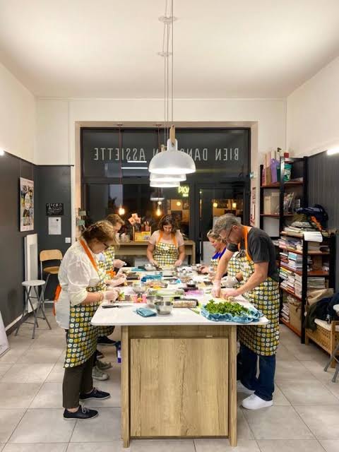 Participants préparant un repas ensemble lors d’un atelier culinaire
