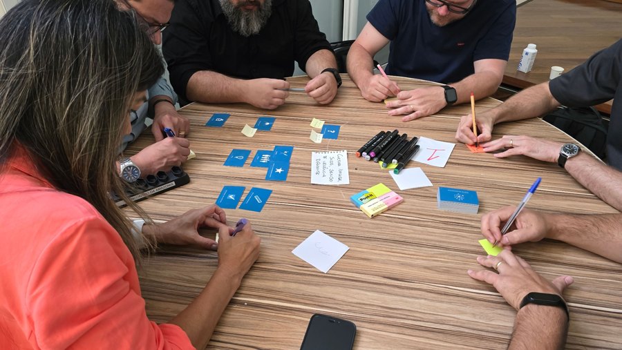 Groupe échangeant autour de cartes et de notes lors d’un jeu de réflexion