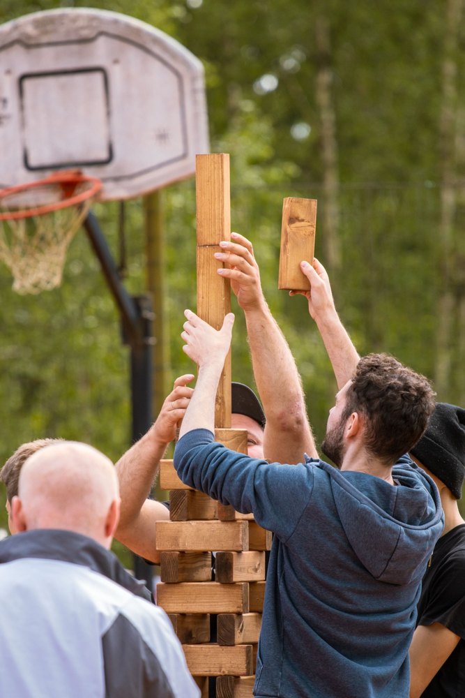 Participants coordonnant leurs gestes pour construire une tour en bois